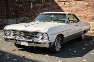 1967 Chevrolet Impala automatique vue de face trois quarts, garée sur un parking extérieur avec des détails de carrosserie chromée à inspecter avant achat