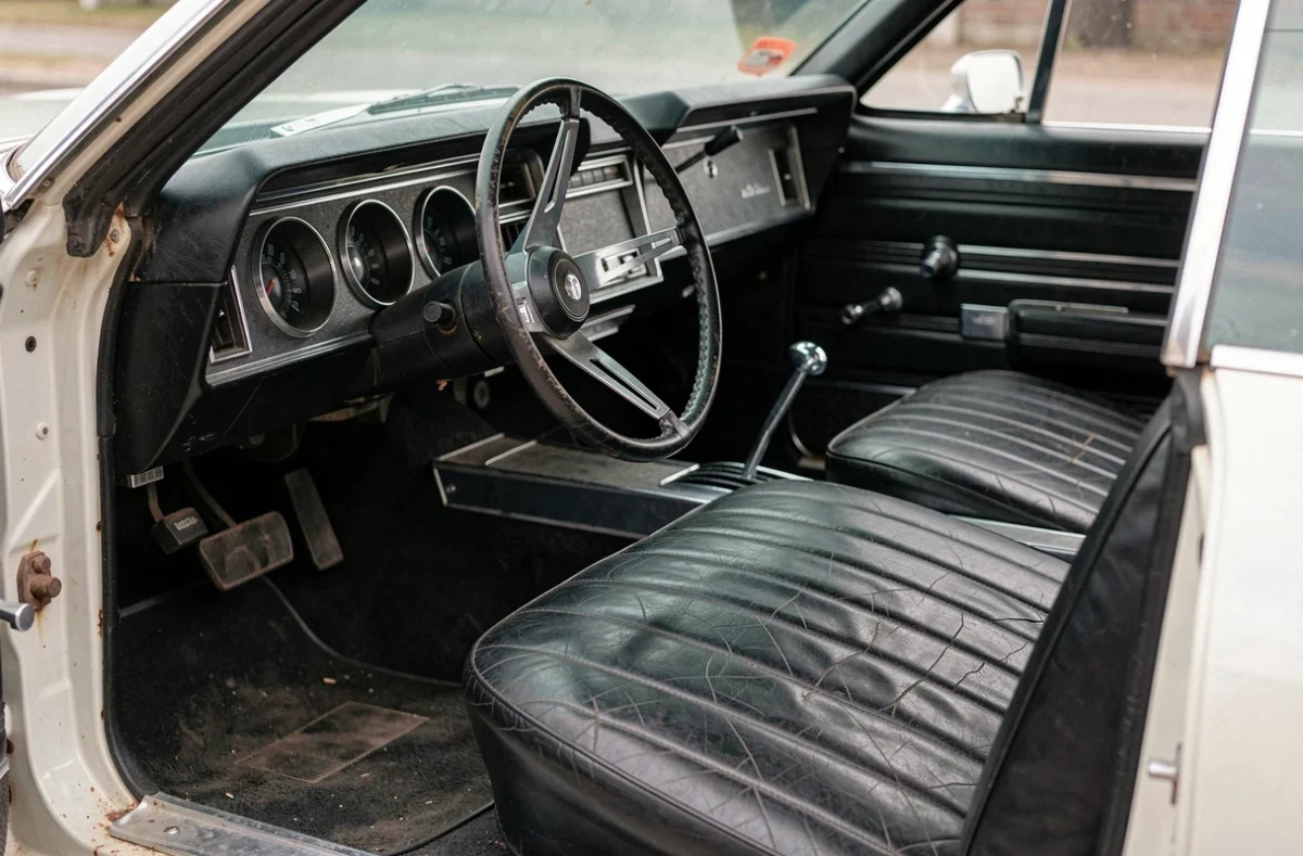 Intérieur d'une Chevrolet Impala 1967 automatique avec tableau de bord d'époque, sièges en vinyle vieilli et colonne de direction automatique à examiner avant achat