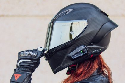 une femme aux cheveux rouges avec un casque moto