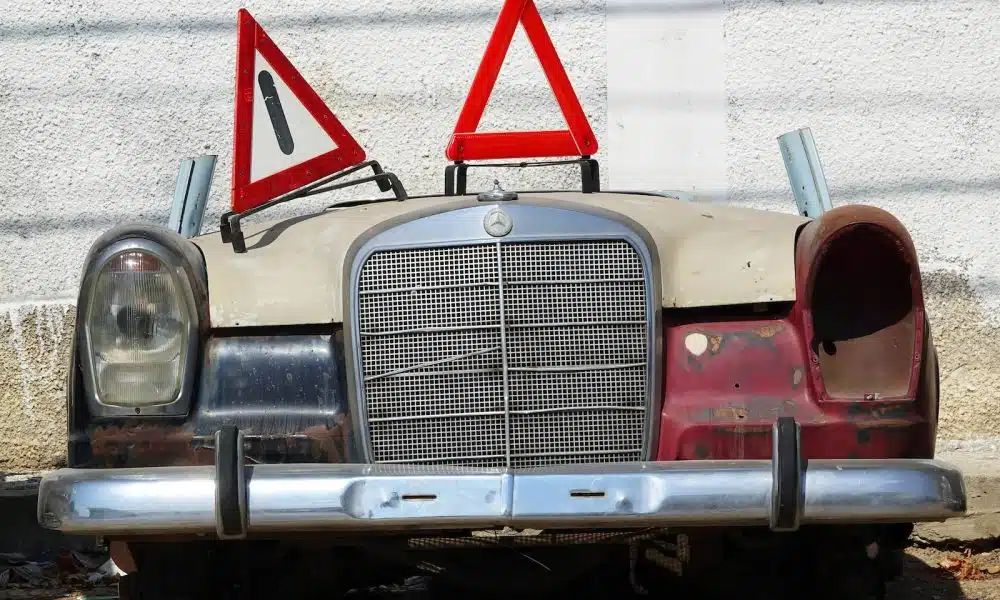 an old car with a warning sign on top of it