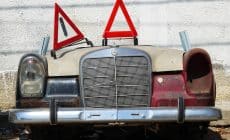 an old car with a warning sign on top of it