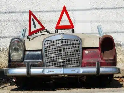 an old car with a warning sign on top of it