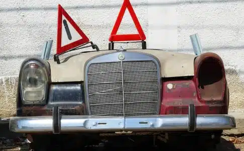 an old car with a warning sign on top of it